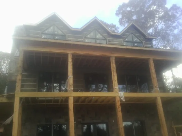 Dormers and porch framing on a large log home under construction — Roof Coating work by our crew in Latrobe