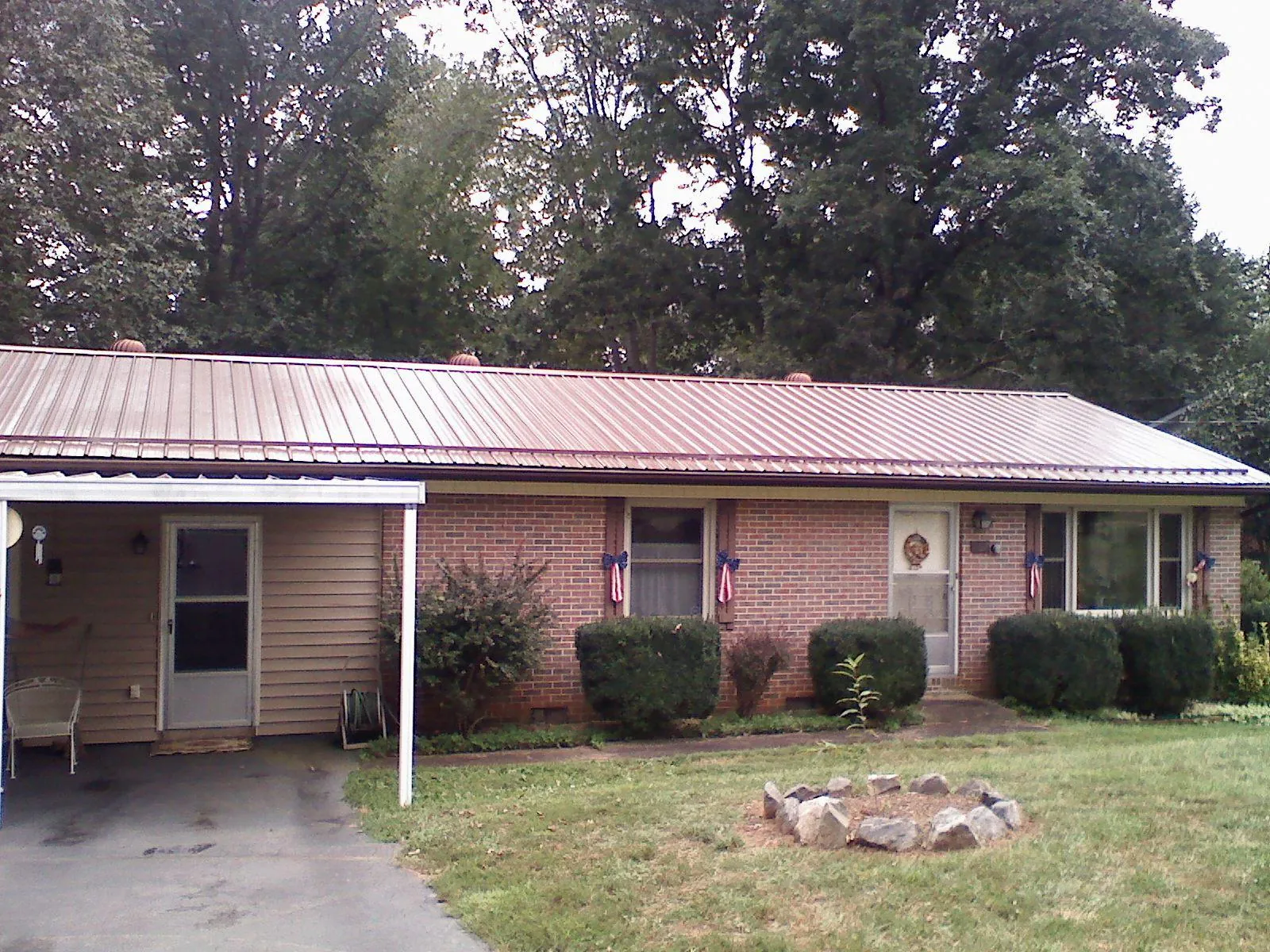 Bronze metal roof and carport on a brick ranch home — Roof Repair work by our crew in Latrobe